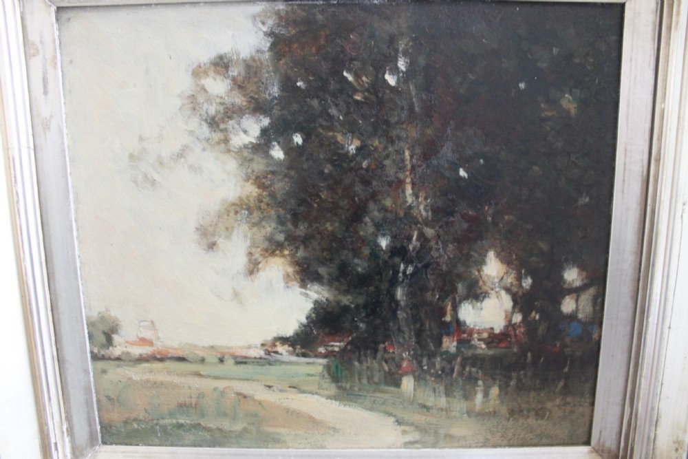 An antique oil painting on wooden panel depicting a muted rural landscape with trees and a track, presented in a wide silver gilt frame. View III