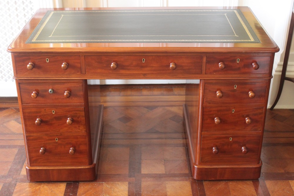 Victorian mahogany pedestal desk with a dark green leather inset top and nine drawers with turned handles. View II