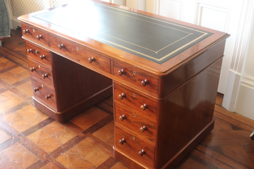 Victorian mahogany pedestal desk with a dark green leather inset top and nine drawers with turned handles. View V