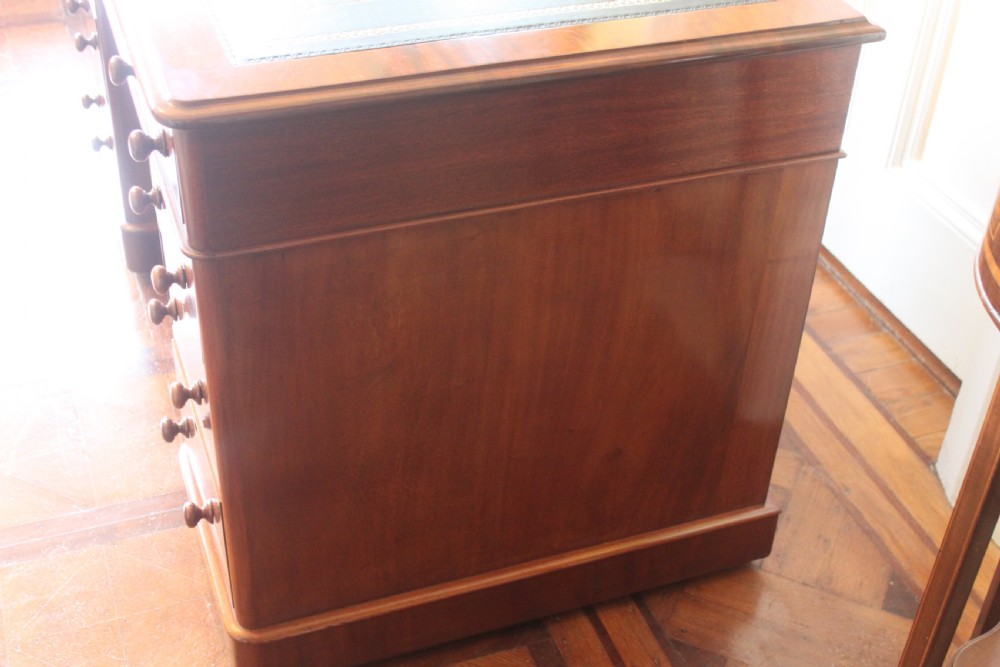 Victorian mahogany pedestal desk with a dark green leather inset top and nine drawers with turned handles. View VI