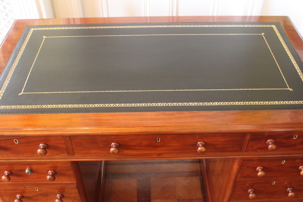 Victorian mahogany pedestal desk with a dark green leather inset top and nine drawers with turned handles. View IX