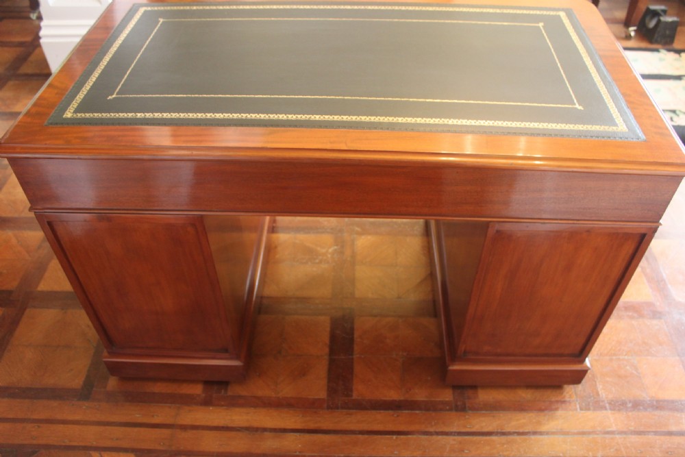 Victorian mahogany pedestal desk with a dark green leather inset top and nine drawers with turned handles. View X