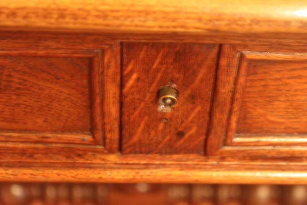An antique French oak writing desk featuring a gold-tooled dark leather top insert, frieze drawers, turned baluster legs, and a stretcher base with a central finial. View XIV