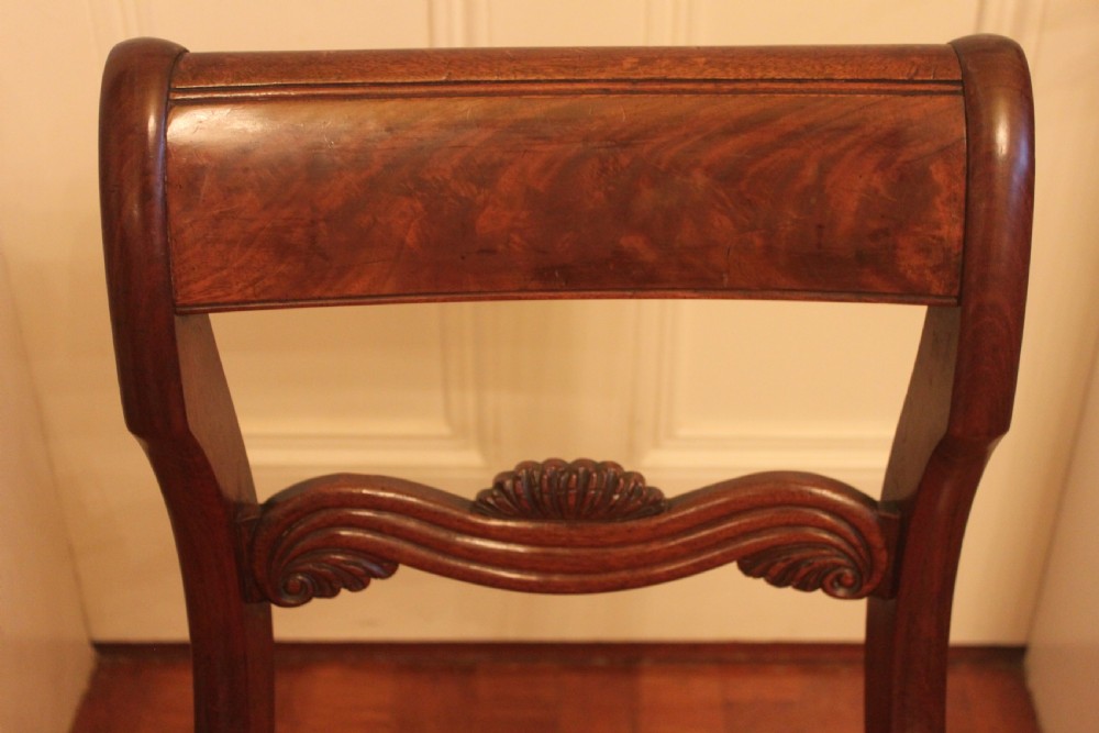 A set of six Regency mahogany dining chairs featuring carved crest rails and red patterned upholstered seats. View IV