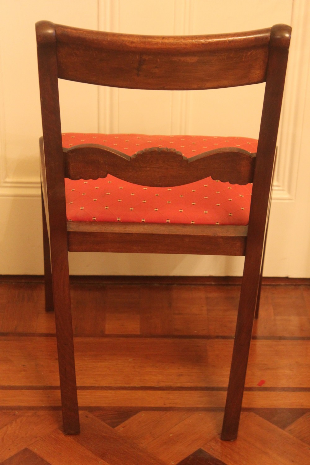 A set of six Regency mahogany dining chairs featuring carved crest rails and red patterned upholstered seats. View VI