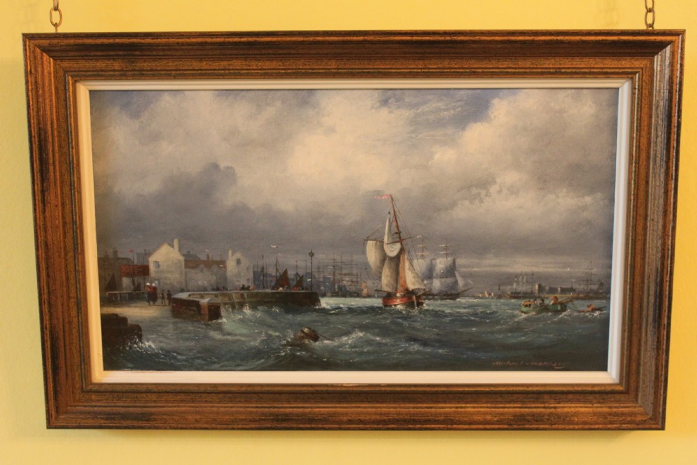 A framed oil on board painting depicting sailing vessels navigating choppy harbour waters under a cloudy sky.