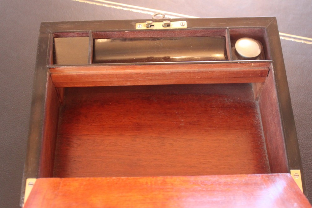 A closed rectangular Victorian burr walnut writing slope decorated with two wide brass straps and a central brass shield inlay. View IX