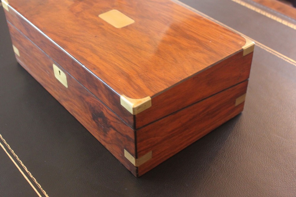 A closed rectangular Victorian writing slope constructed from figured walnut with brass corner mounts and a brass lock escutcheon. View III