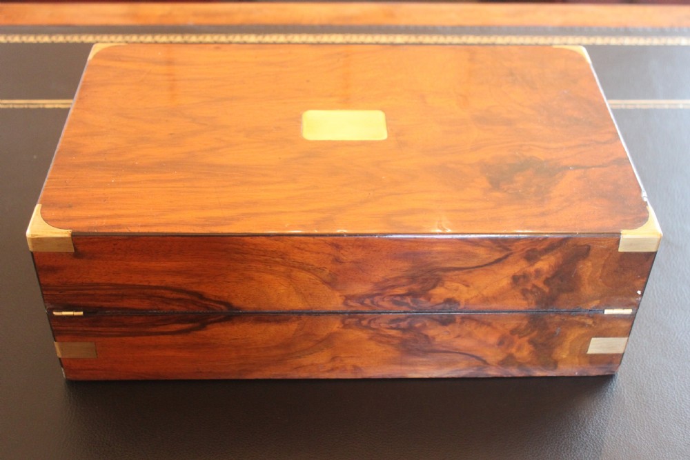 A closed rectangular Victorian writing slope constructed from figured walnut with brass corner mounts and a brass lock escutcheon. View IV
