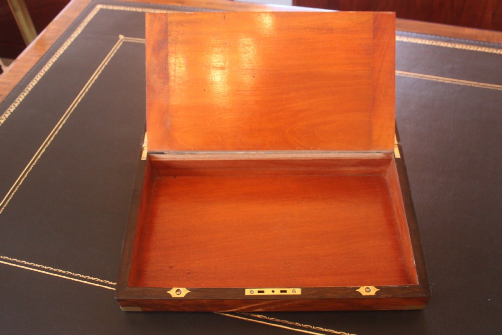 A closed rectangular Victorian writing slope constructed from figured walnut with brass corner mounts and a brass lock escutcheon. View VI