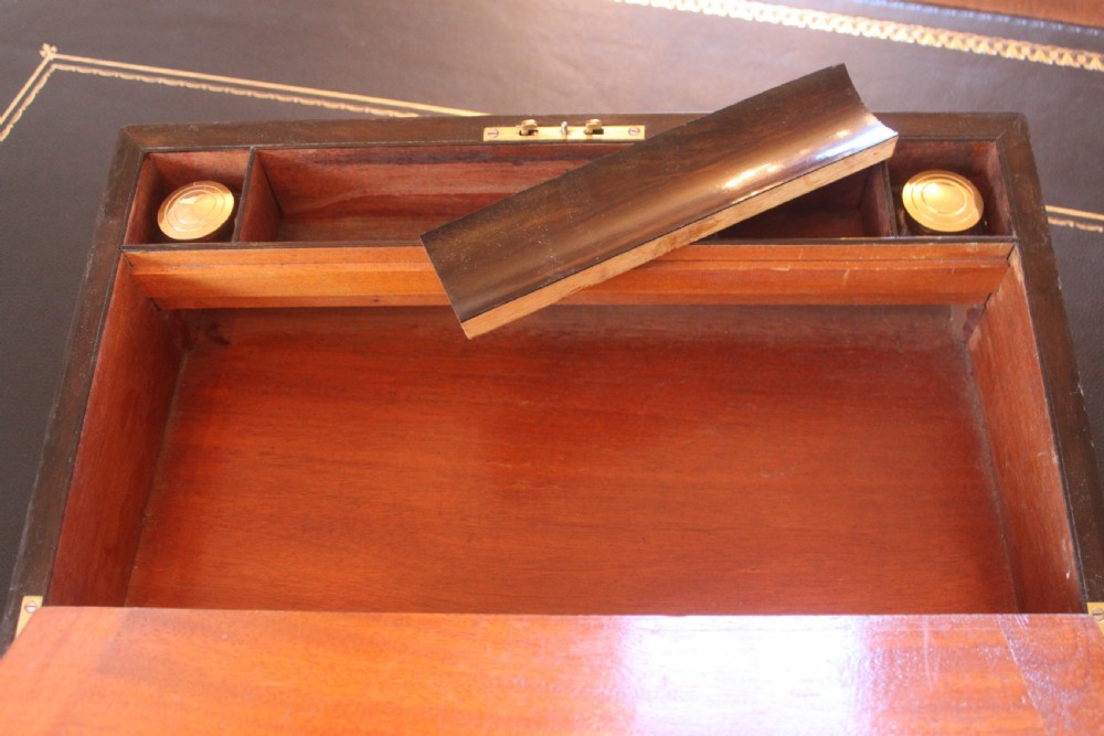 A closed rectangular Victorian writing slope constructed from figured walnut with brass corner mounts and a brass lock escutcheon. View VIII