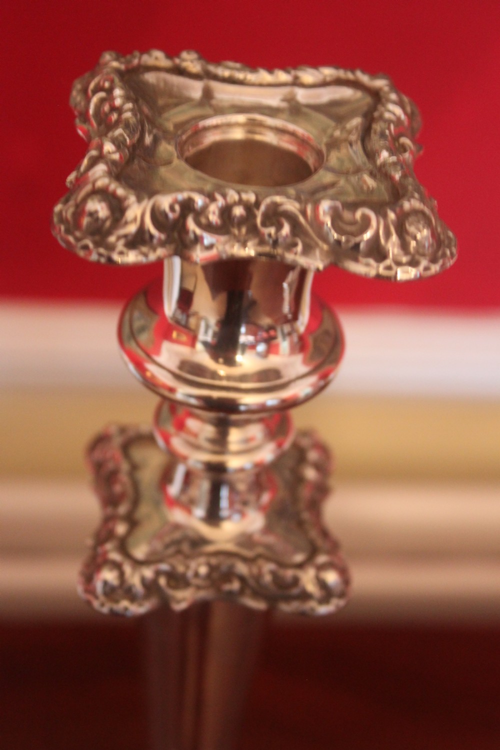 A pair of Victorian silver-plated candlesticks with ornate scroll motifs on square bases and tapered stems. View III