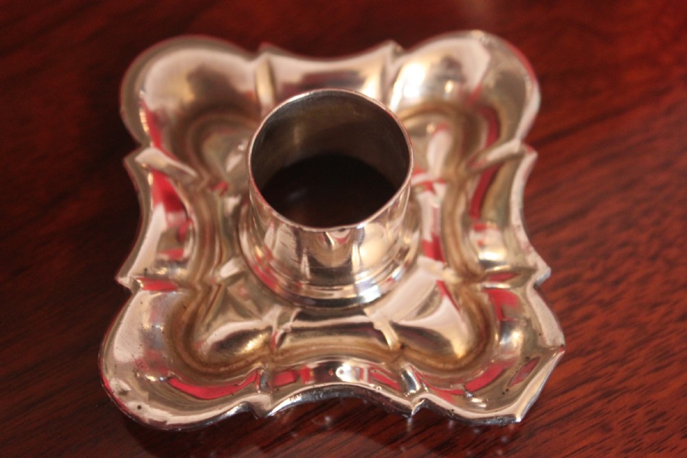 A pair of Victorian silver-plated candlesticks with ornate scroll motifs on square bases and tapered stems. View VI
