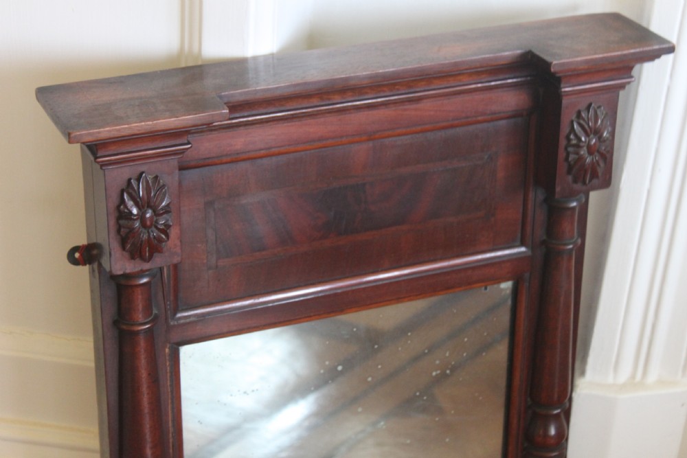 A George IV mahogany pier mirror featuring turned side columns, carved rosettes, a stepped cornice, and an aged glass plate. View II