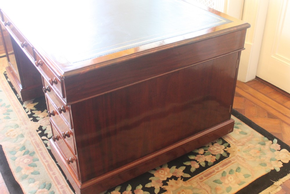 A Victorian mahogany partners desk featuring a green gilded leather writing surface and pedestals with turned wooden drawer knobs. View III