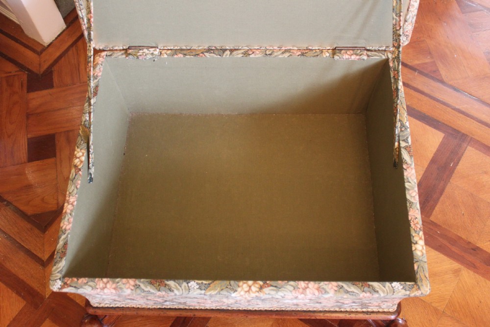 A square Victorian mahogany footstool upholstered in a beige, pink, and green floral tapestry pattern, supported by carved scroll legs with white ceramic castors. View IX