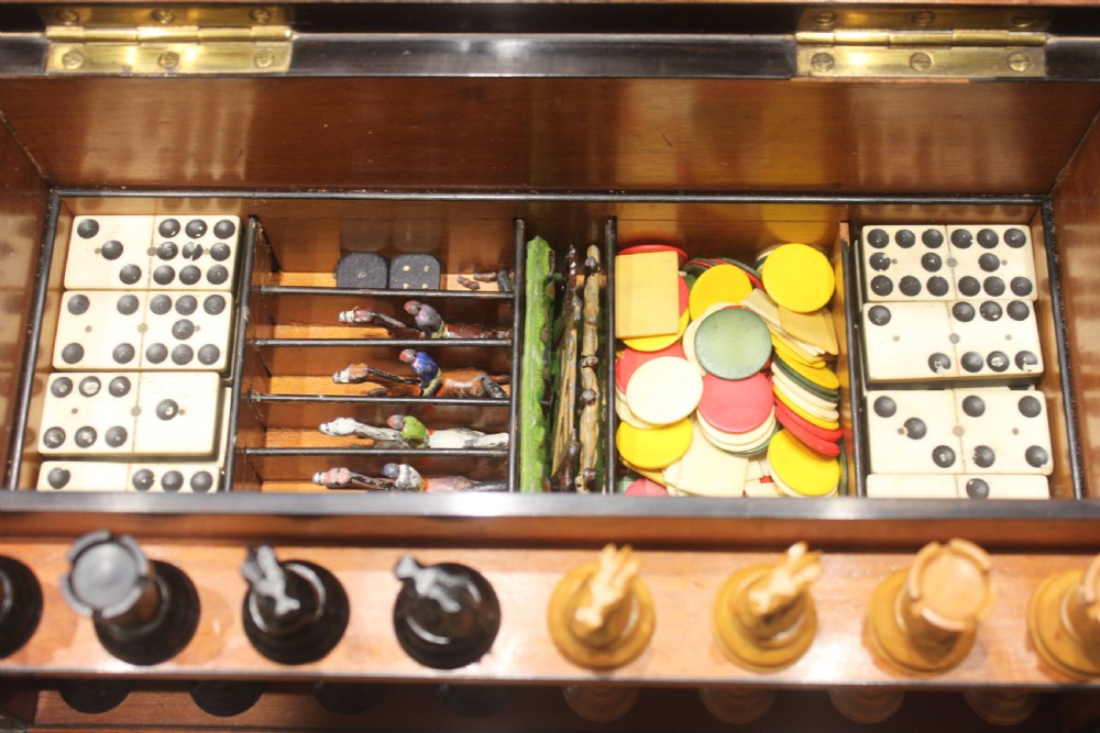 An opened Victorian burr walnut games compendium displaying wooden chess pieces, draughts, cribbage board, and an inlaid game board attached inside the lid. View III