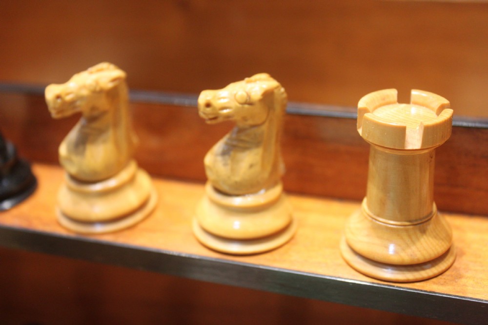 An opened Victorian burr walnut games compendium displaying wooden chess pieces, draughts, cribbage board, and an inlaid game board attached inside the lid. View VII