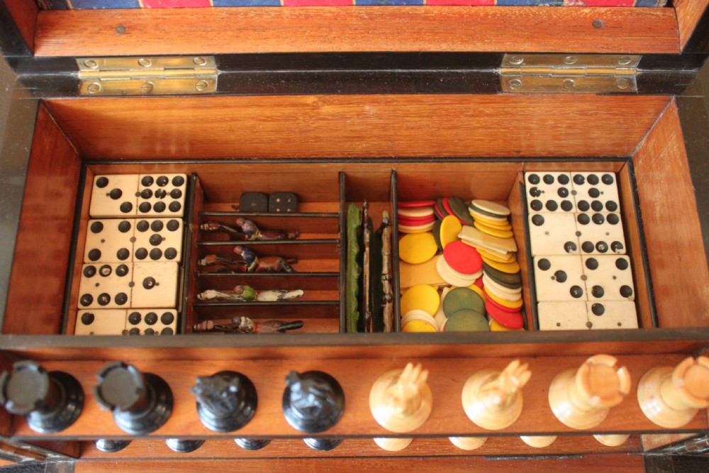 An opened Victorian burr walnut games compendium displaying wooden chess pieces, draughts, cribbage board, and an inlaid game board attached inside the lid. View XIII