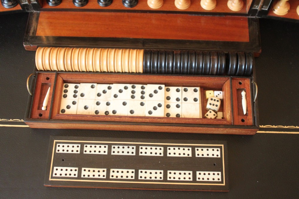 An opened Victorian burr walnut games compendium displaying wooden chess pieces, draughts, cribbage board, and an inlaid game board attached inside the lid. View XIV