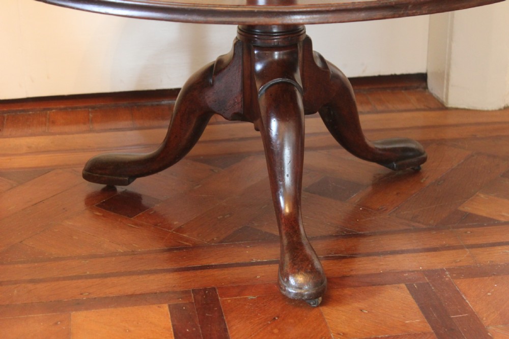 A three-tier Georgian mahogany dumb waiter featuring graduated revolving circular surfaces on a turned central column with a tripod base. View II