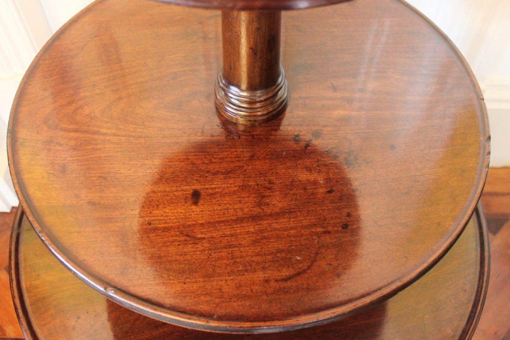 A three-tier Georgian mahogany dumb waiter featuring graduated revolving circular surfaces on a turned central column with a tripod base. View VIII