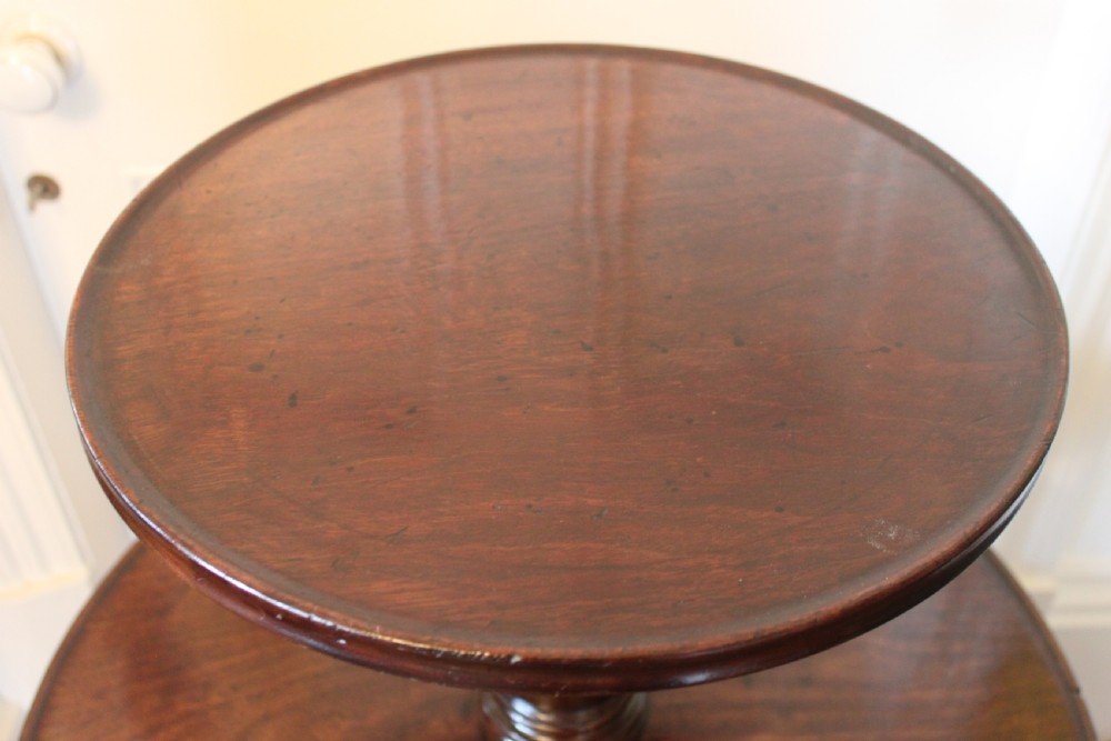 A three-tier Georgian mahogany dumb waiter featuring graduated revolving circular surfaces on a turned central column with a tripod base. View IX