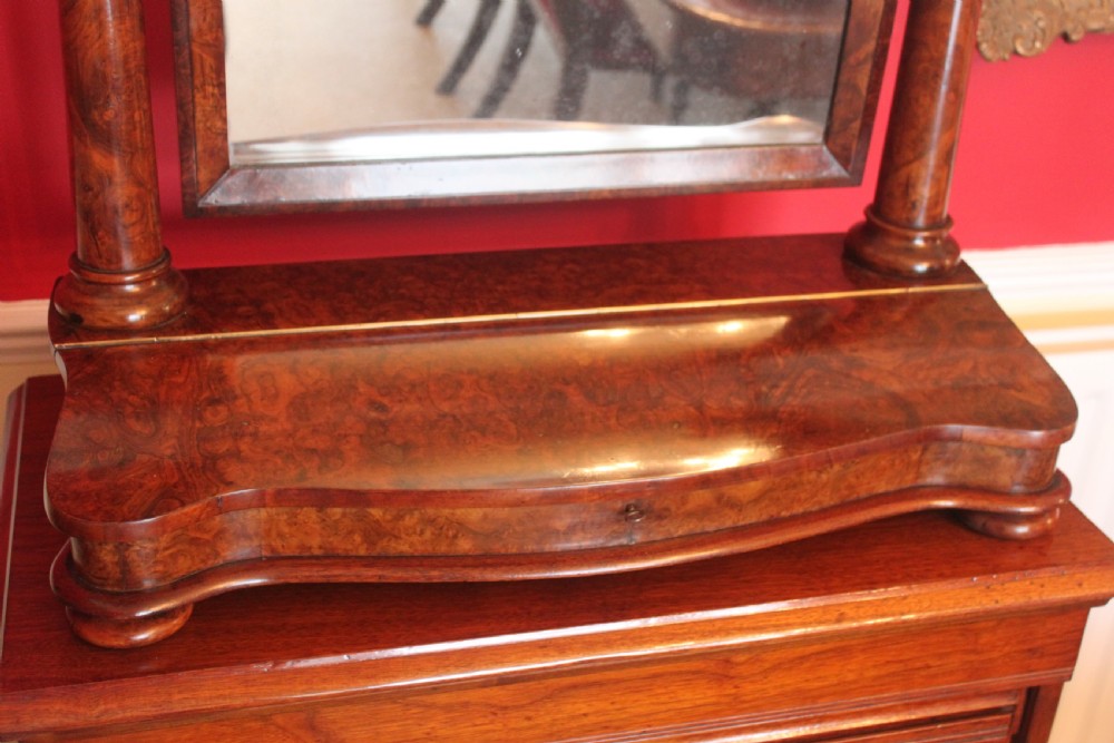 A Victorian burr walnut toilet mirror featuring a tilting arched glass frame set between turned columns with extended brass candle sconces on a shaped plinth base. View III