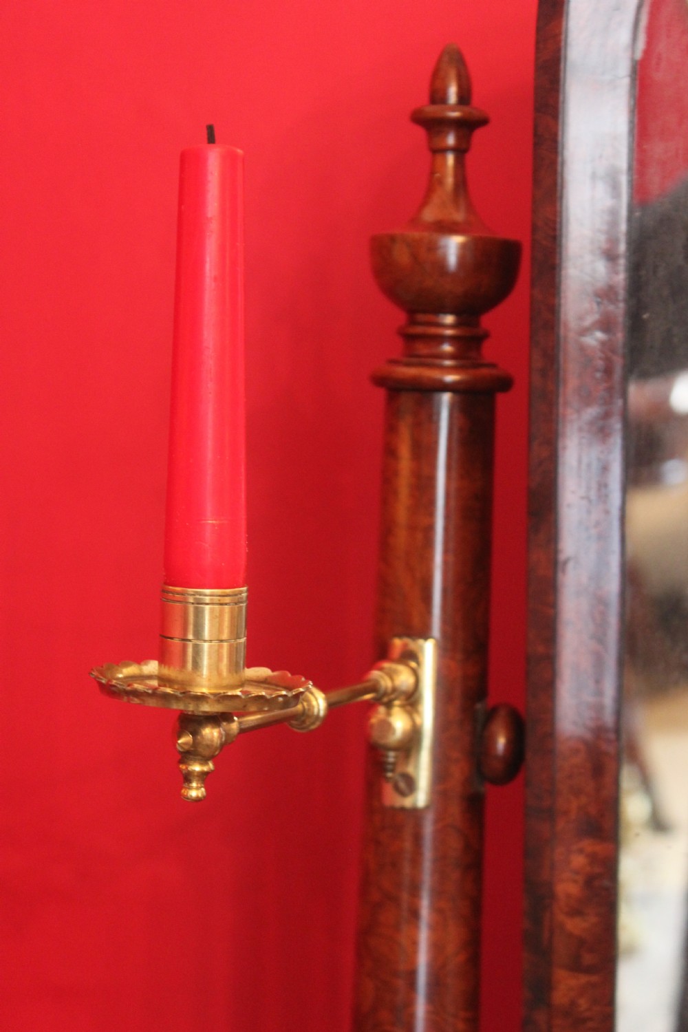 A Victorian burr walnut toilet mirror featuring a tilting arched glass frame set between turned columns with extended brass candle sconces on a shaped plinth base. View IV