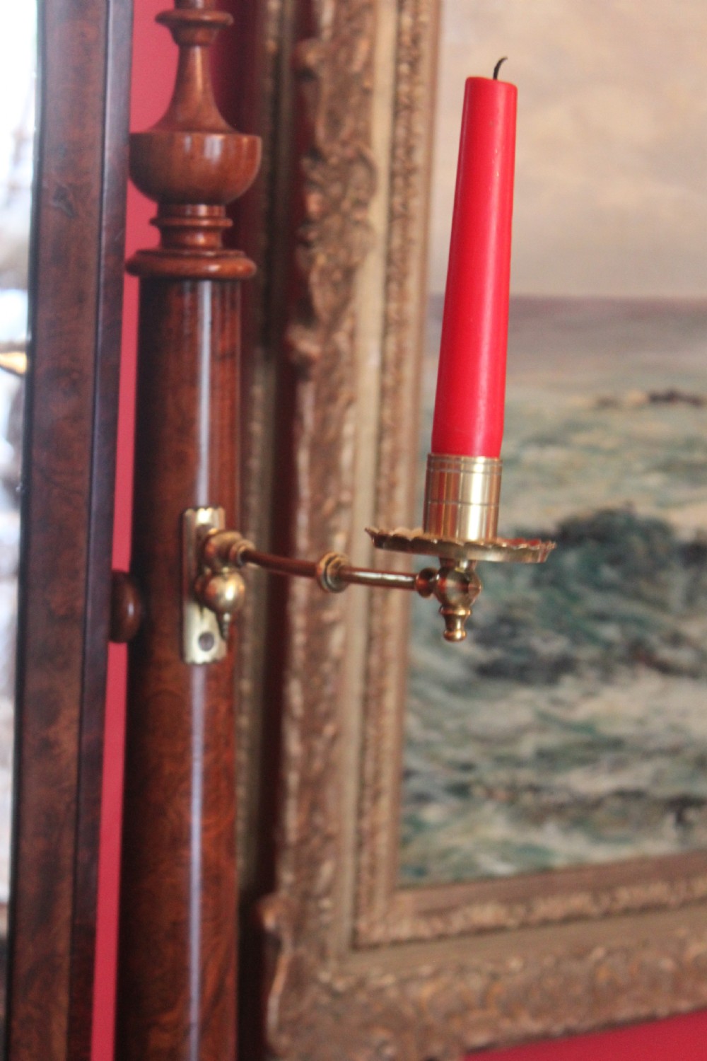 A Victorian burr walnut toilet mirror featuring a tilting arched glass frame set between turned columns with extended brass candle sconces on a shaped plinth base. View V