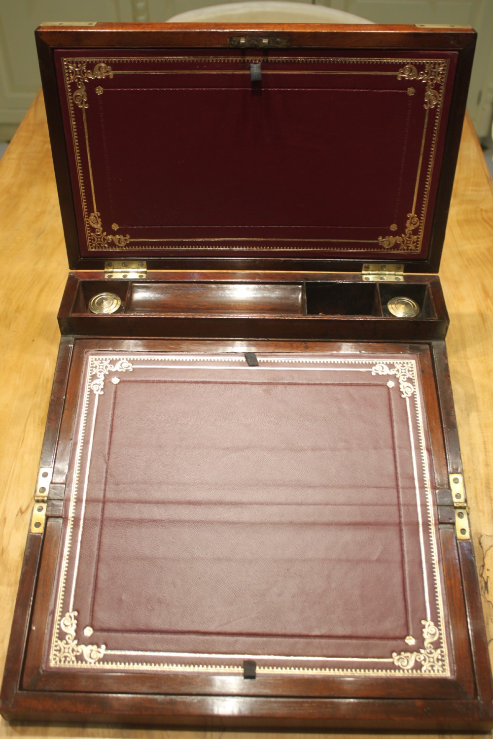 A closed rectangular late Georgian mahogany campaign writing slope featuring flush brass corner brackets, protective straps, and a decorative brass keyhole escutcheon. View VIII