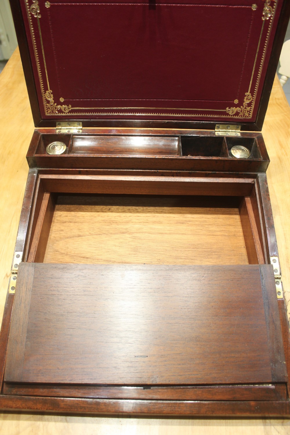 A closed rectangular late Georgian mahogany campaign writing slope featuring flush brass corner brackets, protective straps, and a decorative brass keyhole escutcheon. View X