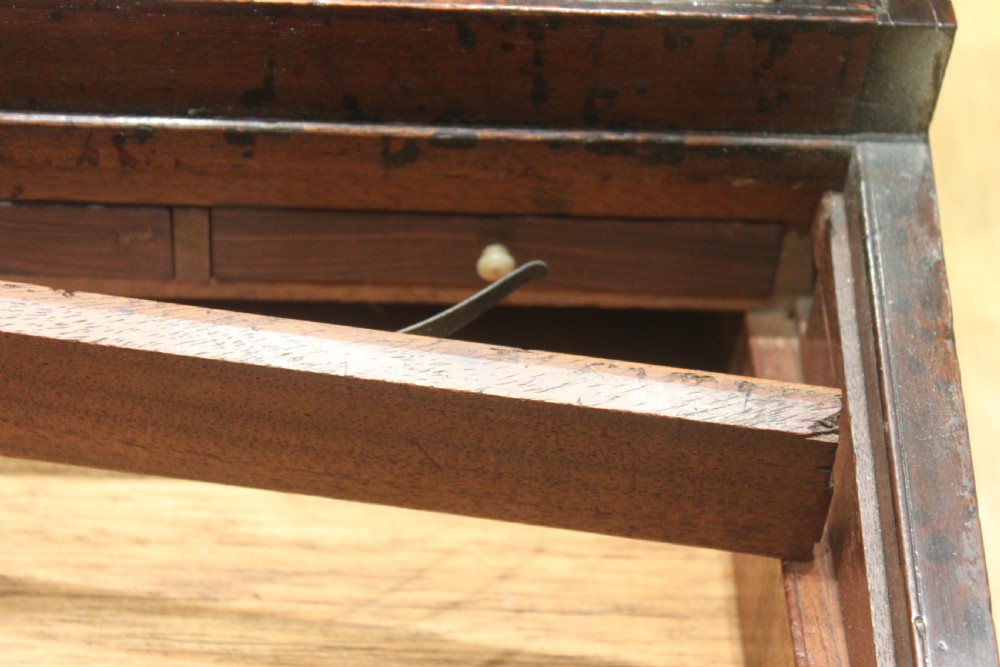A closed rectangular late Georgian mahogany campaign writing slope featuring flush brass corner brackets, protective straps, and a decorative brass keyhole escutcheon. View XIV
