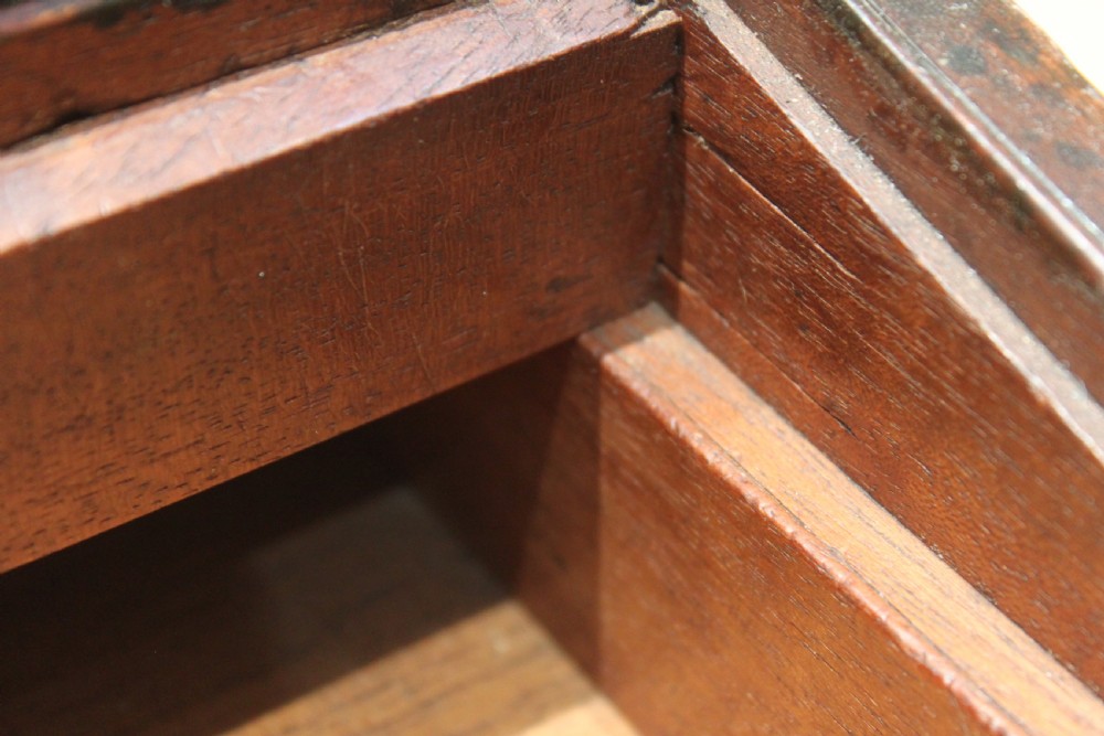 A closed rectangular late Georgian mahogany campaign writing slope featuring flush brass corner brackets, protective straps, and a decorative brass keyhole escutcheon. View XVI