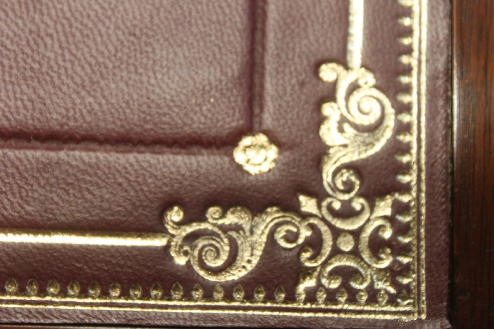 A closed rectangular late Georgian mahogany campaign writing slope featuring flush brass corner brackets, protective straps, and a decorative brass keyhole escutcheon. View XVII