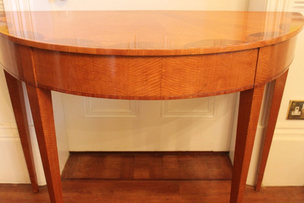 An early 19th-century semi-circular satinwood demi-lune console table featuring decorative top marquetry and four square tapered legs. View VII