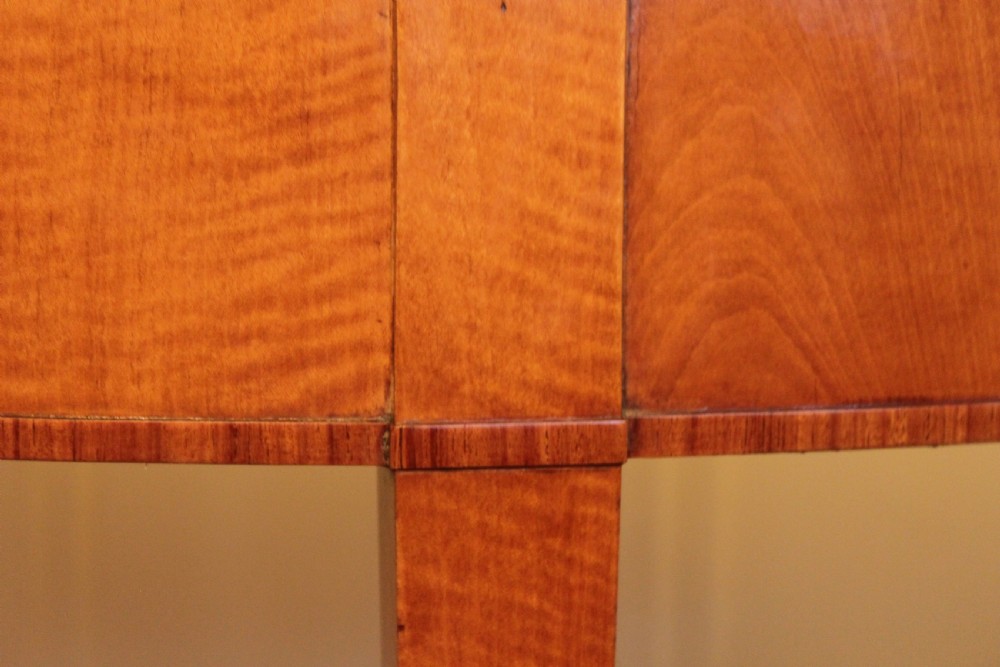 An early 19th-century semi-circular satinwood demi-lune console table featuring decorative top marquetry and four square tapered legs. View IX