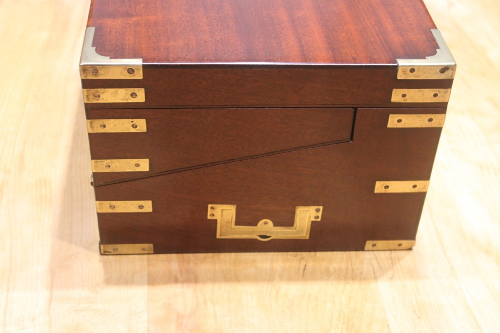A 19th-century rectangular mahogany campaign writing slope with flush brass corner brackets, brass side strapping, an inlaid brass keyhole escutcheon, and a central brass plaque on the lid. View III