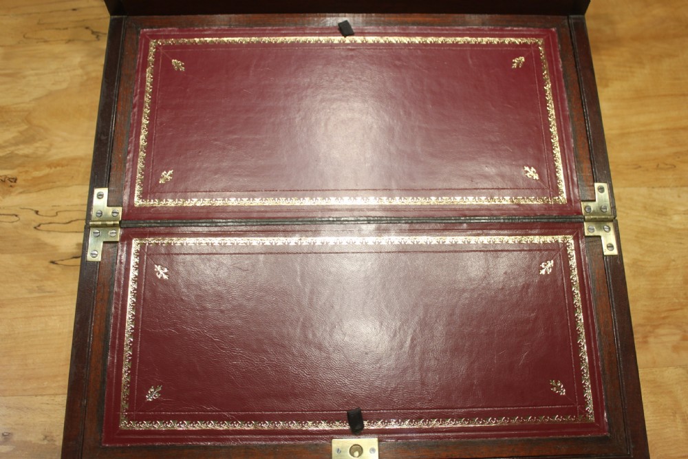 A 19th-century rectangular mahogany campaign writing slope with flush brass corner brackets, brass side strapping, an inlaid brass keyhole escutcheon, and a central brass plaque on the lid. View VIII