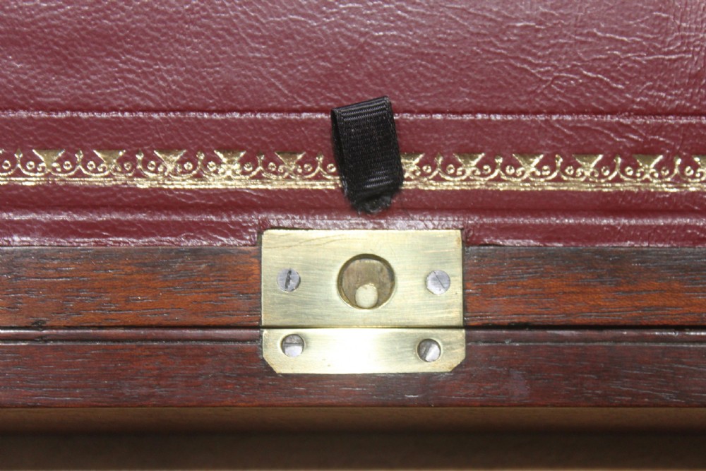 A 19th-century rectangular mahogany campaign writing slope with flush brass corner brackets, brass side strapping, an inlaid brass keyhole escutcheon, and a central brass plaque on the lid. View IX