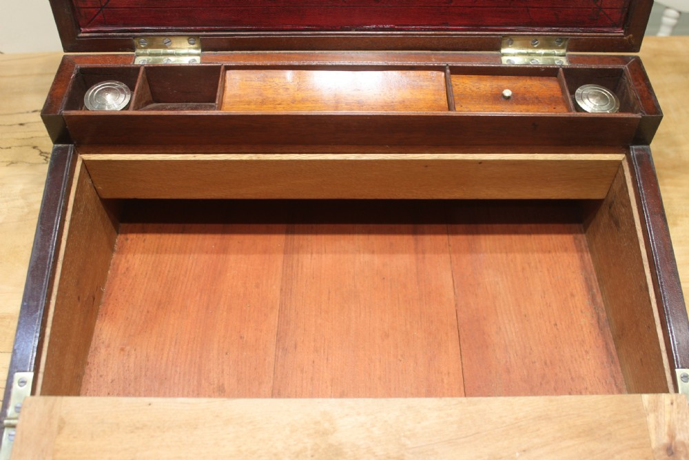 A 19th-century rectangular mahogany campaign writing slope with flush brass corner brackets, brass side strapping, an inlaid brass keyhole escutcheon, and a central brass plaque on the lid. View XI