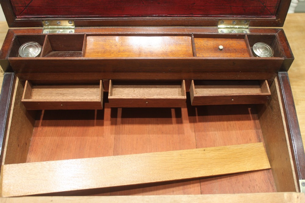 A 19th-century rectangular mahogany campaign writing slope with flush brass corner brackets, brass side strapping, an inlaid brass keyhole escutcheon, and a central brass plaque on the lid. View XII