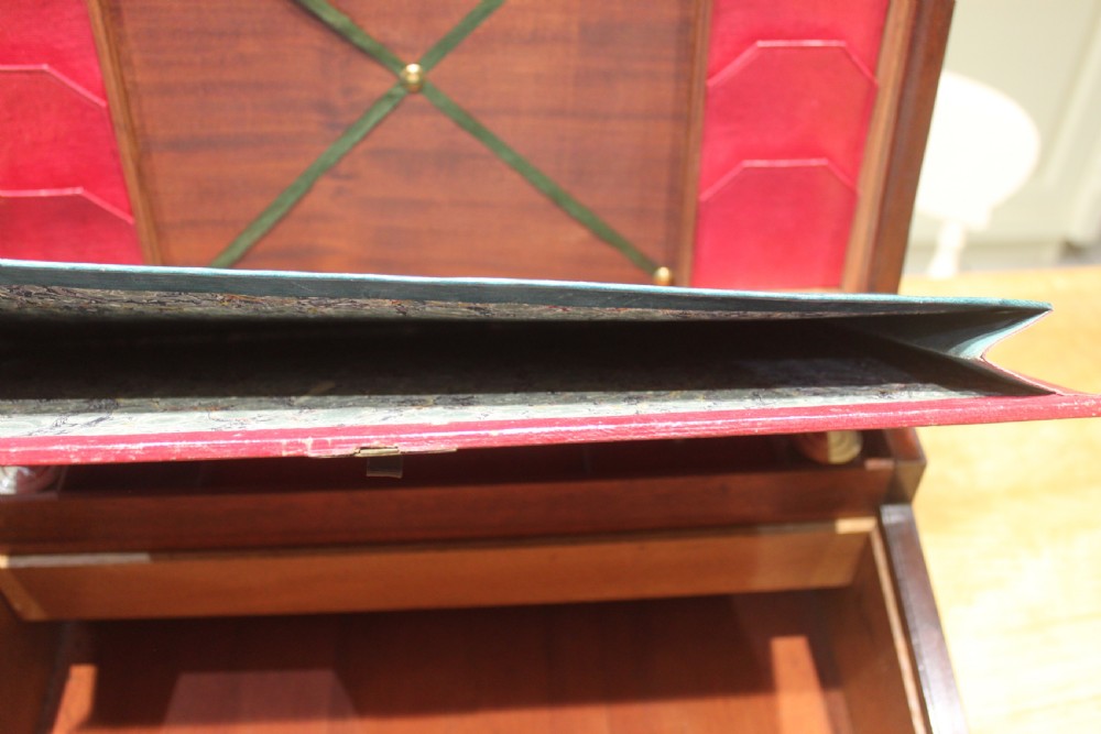 A 19th-century rectangular mahogany campaign writing slope with flush brass corner brackets, brass side strapping, an inlaid brass keyhole escutcheon, and a central brass plaque on the lid. View XV