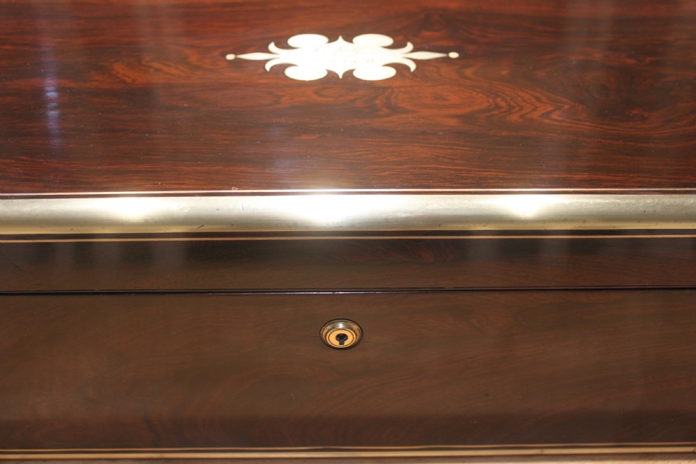 A closed rectangular dark rosewood writing slope featuring brass-bound corners, fine brass line inlay, a brass keyhole escutcheon, and an engraved central brass cartouche. View II