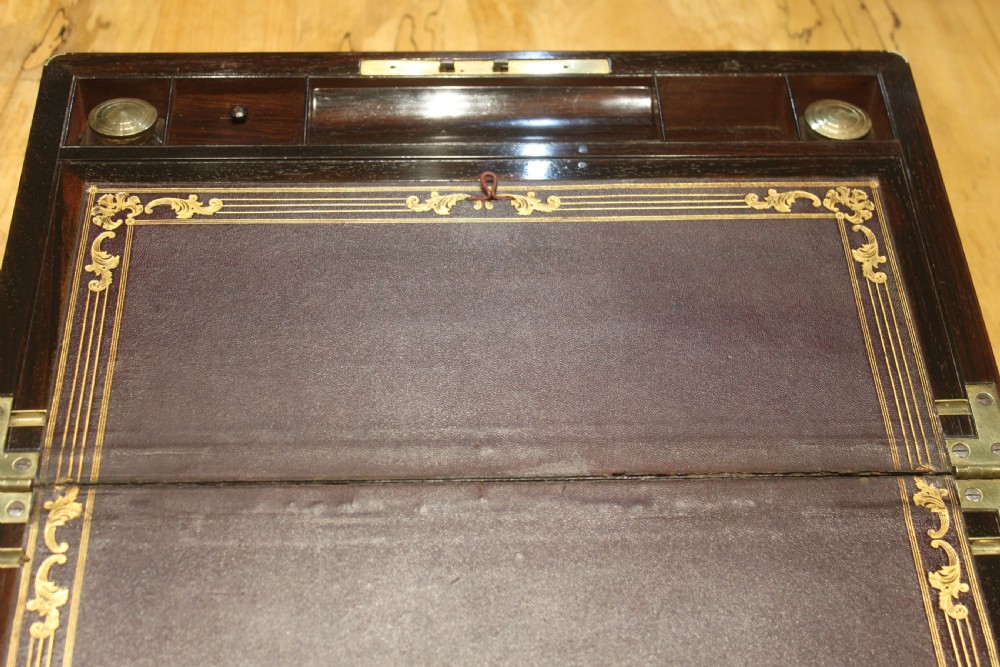 A closed rectangular dark rosewood writing slope featuring brass-bound corners, fine brass line inlay, a brass keyhole escutcheon, and an engraved central brass cartouche. View VIII