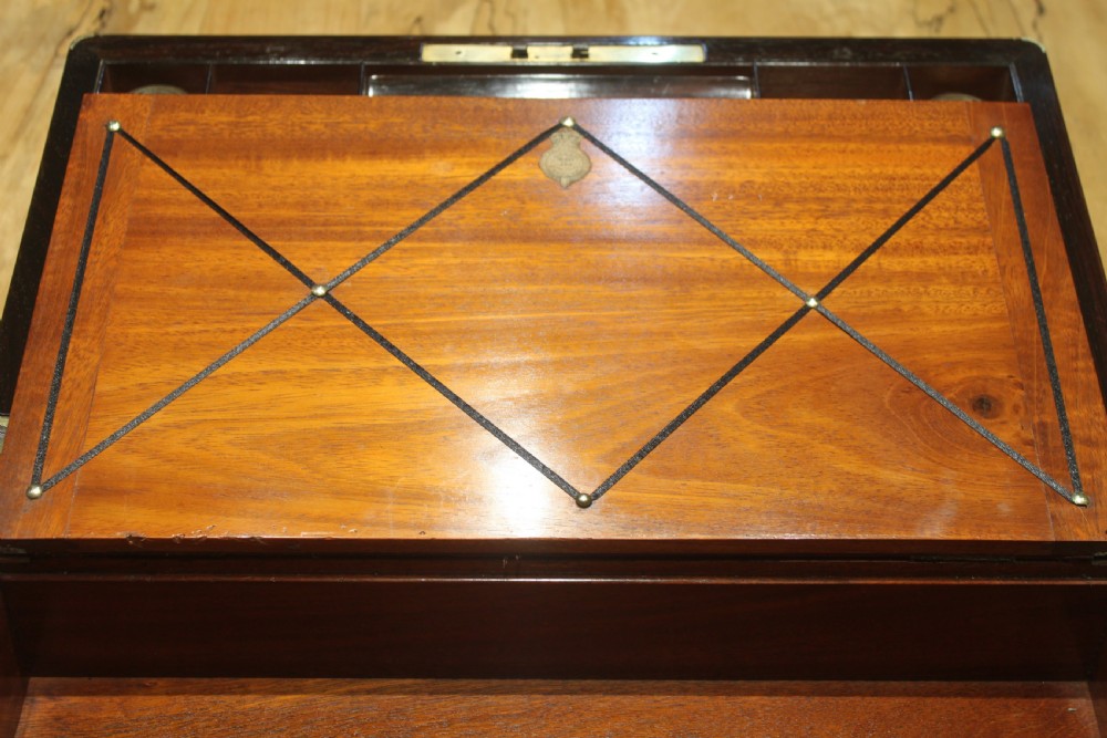 A closed rectangular dark rosewood writing slope featuring brass-bound corners, fine brass line inlay, a brass keyhole escutcheon, and an engraved central brass cartouche. View IX