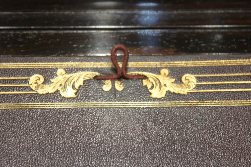 A closed rectangular dark rosewood writing slope featuring brass-bound corners, fine brass line inlay, a brass keyhole escutcheon, and an engraved central brass cartouche. View XII