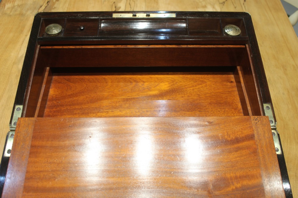 A closed rectangular dark rosewood writing slope featuring brass-bound corners, fine brass line inlay, a brass keyhole escutcheon, and an engraved central brass cartouche. View XIII