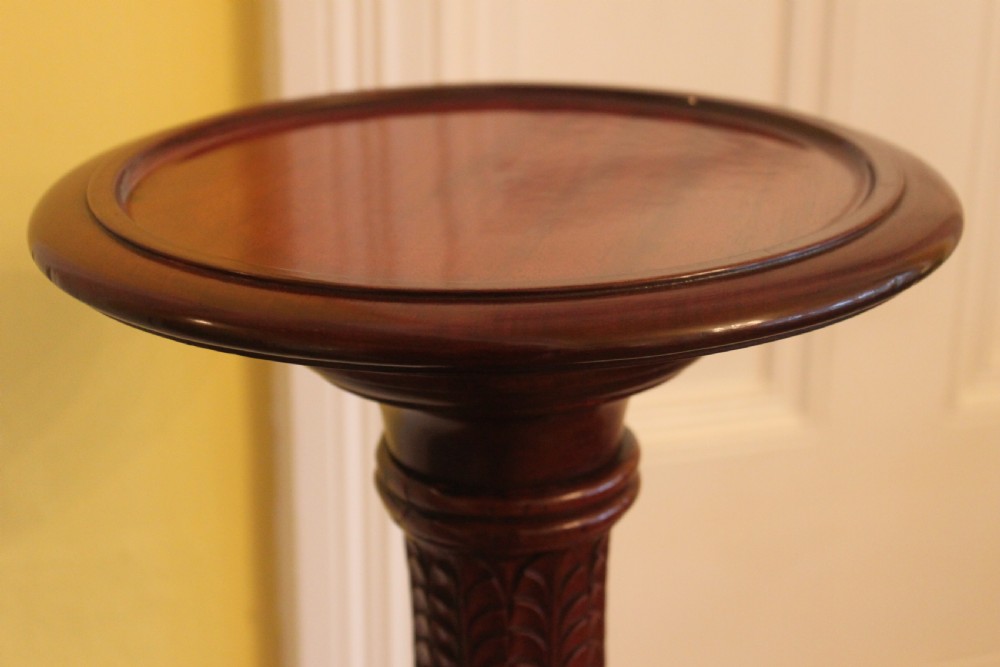 A tall nineteenth-century dark mahogany torchiere stand featuring a carved spiral twist column, acanthus leaf motifs, and a tripod base. View V