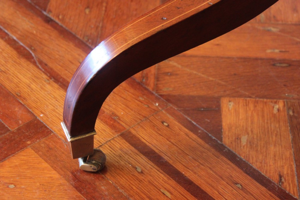 A full-length Sheraton style mahogany cheval dressing mirror with turned finials, splayed legs, brass castors, and a tilting frame. View IV